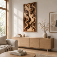 Tall framed wall art with layered wave relief in light and dark wood above a light oak sideboard in daylight