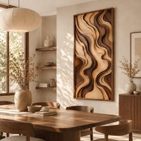 Tall framed wall art with layered wave relief in light and dark wood beside a dining table in natural light