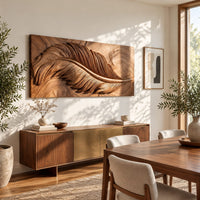 Carved wood wall art panel with a large feather in deep relief in a bright sunroom with green plants
