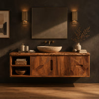 Wall mounted bathroom vanity with a live edge top and leaf carved fronts in a dark studio against a charcoal plaster wall