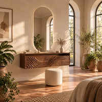 Floating makeup vanity with an open top niche and a wave carved front in a bright bedroom with arched windows and plants