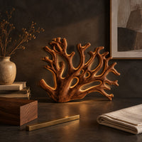 Corner detail of wall sconce shaped like branching coral with open carved limbs beside wood, brass and linen samples