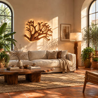Wall sconce shaped like branching coral with open carved limbs in a bright living room with arched windows and plants