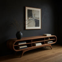 Warm grain capsule TV cabinet on splayed legs in a dark studio against a charcoal wall