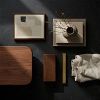 Corner detail of warm grain capsule TV cabinet on splayed legs beside wood, brass and linen samples