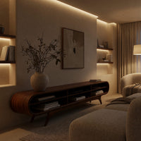 Warm grain capsule TV cabinet on splayed legs in an evening room lit by two lamps
