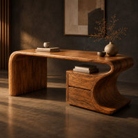 Corner detail of sculpted wood desk with a waterfall side panel and a two drawer pedestal beside wood, brass and linen samples