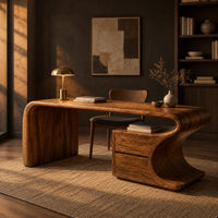 Sculpted wood desk with a waterfall side panel and a two drawer pedestal in a dark home office at golden hour