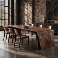 Waterfall dining table with carved grain slab ends and open space below in an industrial loft dining room with exposed brick