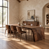 Waterfall dining table with carved grain slab ends and open space below in a bright open plan dining room