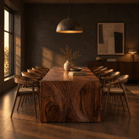 Waterfall dining table with carved swirl grain end panels in a dark dining room at golden hour