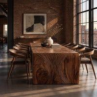 Waterfall dining table with carved swirl grain end panels in an industrial loft dining room with exposed brick