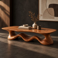 Corner detail of coffee table with a freeform slab top on a rolling wave shaped base beside wood, brass and linen samples