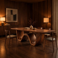 Rectangular dining table on a thick wave shaped base in an evening dining room with walnut wall paneling