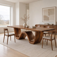 Rectangular dining table on a thick wave shaped base in a Scandinavian dining room with white walls