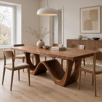 Rectangular dining table with a wave shaped base and open arch ends in a Scandinavian dining room with white walls