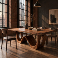 Rectangular dining table with a wave shaped base and open arch ends in an industrial loft dining room with exposed brick