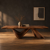 Rectangular dining table with a thick slab top on two ribbon like wave legs in a dark studio against a charcoal plaster wall