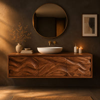 Long floating bathroom vanity cabinet with three wave carved front panels in a dark bathroom at golden hour