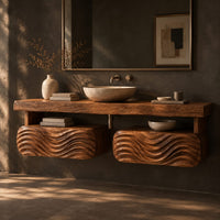 Floating vanity with a thick slab top over two wave carved pods, three-quarter view showing the grain