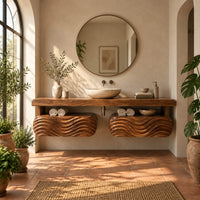 Floating vanity with a thick slab top over two wave carved pods in a bright bathroom with arched windows and plants