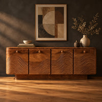 Wooden sideboard with four wave carved doors and a plinth base in a dark studio against a charcoal plaster wall