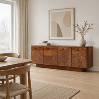 Wooden sideboard with four wave carved doors and a plinth base in a Scandinavian dining room with white walls