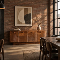 Wooden sideboard with four wave carved doors and a plinth base in an industrial loft dining room with exposed brick