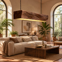 Linear wooden pendant light with wave carved sides and a glowing underside in a bright living room with arched windows and plants