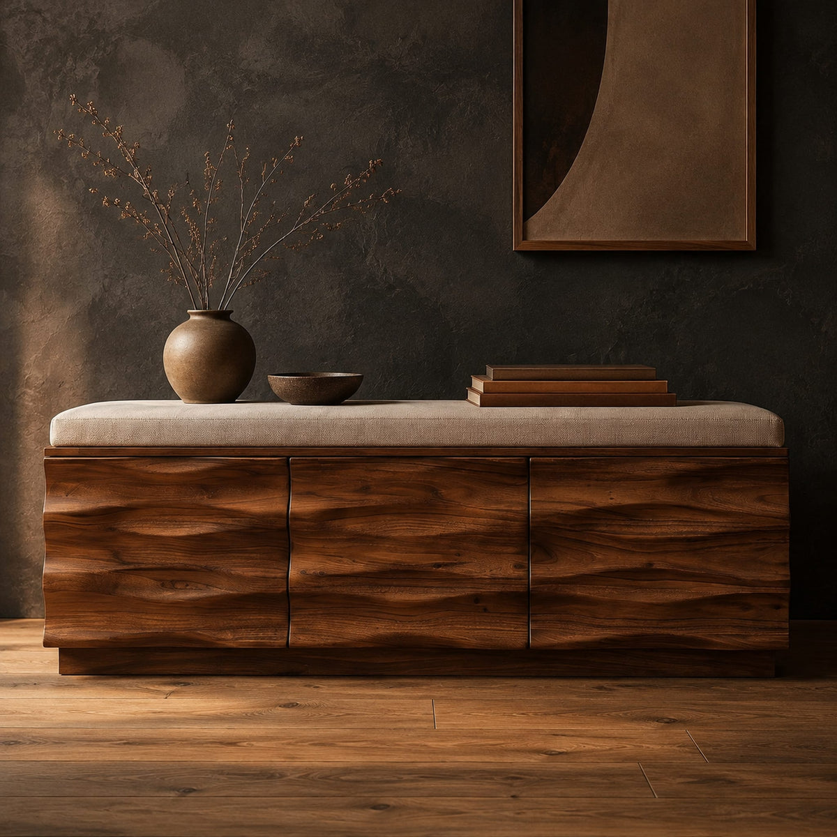 Bench with a padded seat and three wave carved front panels in a dark studio against a charcoal plaster wall