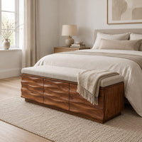 Bench with a padded seat and three wave carved front panels in a Scandinavian bedroom with white walls
