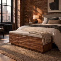 Bench with a padded seat and three wave carved front panels in an industrial loft bedroom with exposed brick