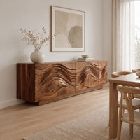 Long sideboard with deep wave carving across the full front in a Scandinavian dining room with white walls