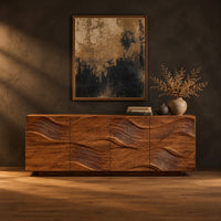 Wave carved wooden sideboard with four relief panels on a plinth base in a dark studio against a charcoal plaster wall