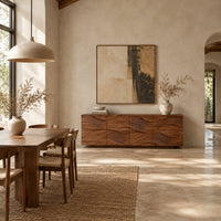 Wave carved wooden sideboard with four relief panels on a plinth base in a bright open plan dining room