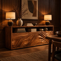 Low sideboard with three carved wave panels and an open display shelf above in an evening dining room with walnut wall paneling