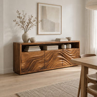 Low sideboard with three carved wave panels and an open display shelf above in a Scandinavian dining room with white walls