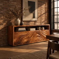 Low sideboard with three carved wave panels and an open display shelf above in an industrial loft dining room with exposed brick