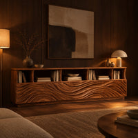 Low tv stand with wave carved front panels and a row of open cubbies in an evening living room with walnut wall paneling