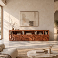 Low tv stand with wave carved front panels and a row of open cubbies in a bright open plan living room