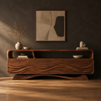 Tv stand with wave carved panels, an open top shelf and an arched base in a dark studio against a charcoal plaster wall