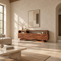 Tv stand with wave carved panels, an open top shelf and an arched base in a bright open plan living room
