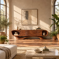 Wooden tv stand with oval end niches, wave carved panels and a swept base in a bright living room with arched windows and plants