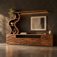 Corner detail of long wood media cabinet with wave carved fronts and an s shaped shelf tower beside wood, brass and linen samples