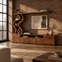 Long wood media cabinet with wave carved fronts and an s shaped shelf tower in an industrial loft living room with exposed brick