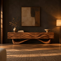 Tv stand with a wave carved cabinet on a sweeping sculpted base in a dark living room at golden hour