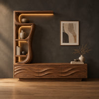 Low wave carved cabinet with a tall open shelf tower and a top shelf in a dark studio against a charcoal plaster wall
