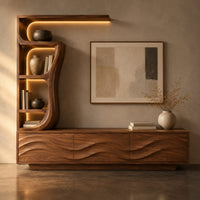 Corner detail of low wave carved cabinet with a tall open shelf tower and a top shelf beside wood, brass and linen samples
