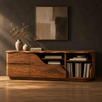 Low wooden tv stand with a wave cut front and upright slots in a dark studio against a charcoal plaster wall