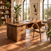 Desk with a thick slab top, three drawer pedestal and a wave shaped leg in a bright home office with arched windows and plants